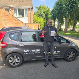 Smiling student holding a driving certificate after passing their driving test.