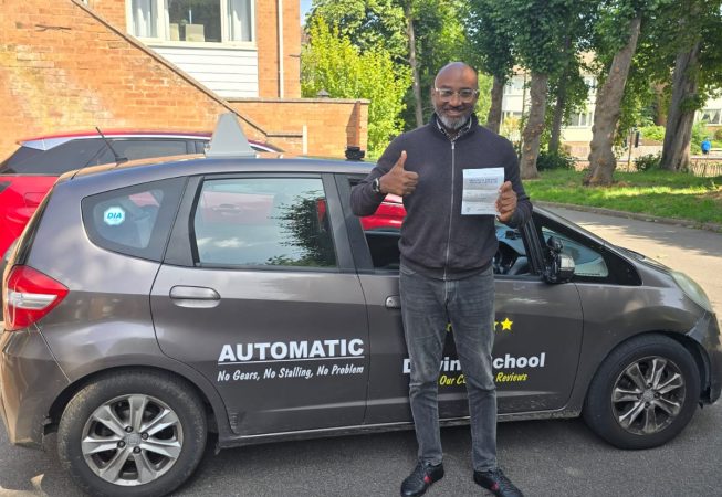 Smiling student holding a driving certificate after passing their driving test.