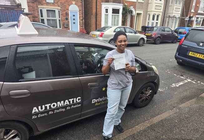 Gina smiling after passing her driving test with a perfect score.
