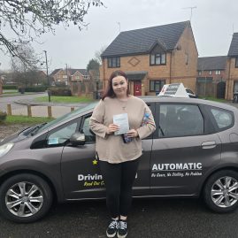 Chelsea holding her pass certificate after successfully passing her driving test with zero minors at EXL Drivers in Rugby.