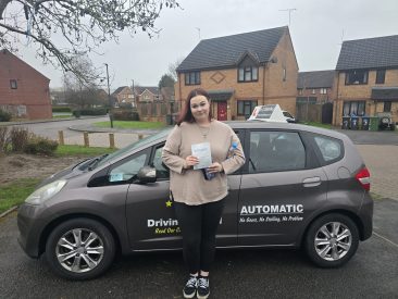 Chelsea holding her pass certificate after successfully passing her driving test with zero minors at EXL Drivers in Rugby.