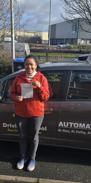 Ritu smiling beside a car after passing her driving test on her first attempt.