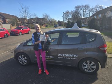 Stela proudly holding her driving test pass certificate after passing on her first try
